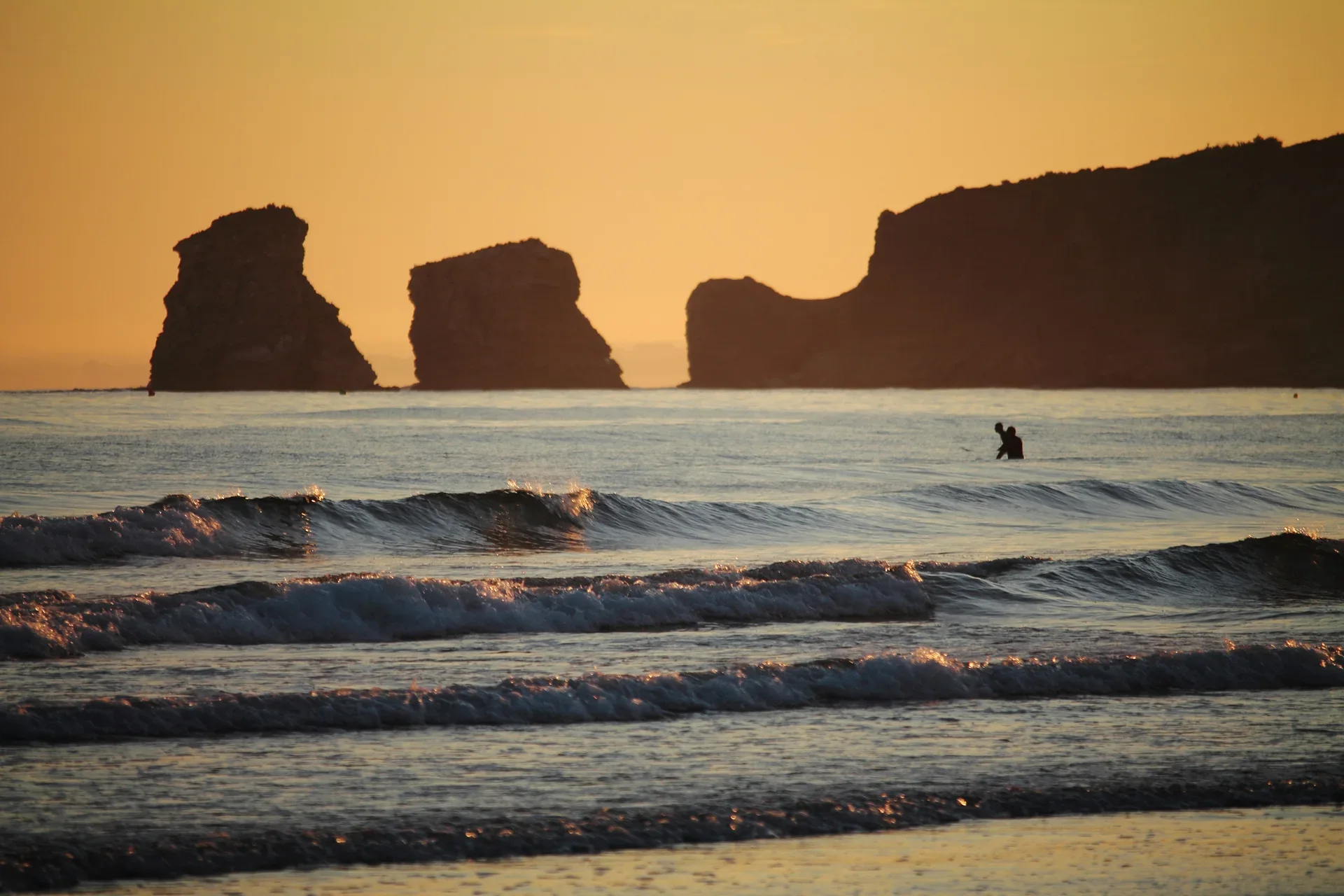 Small waves at sunset with the twin rocks off Hendaye in the Basque Country